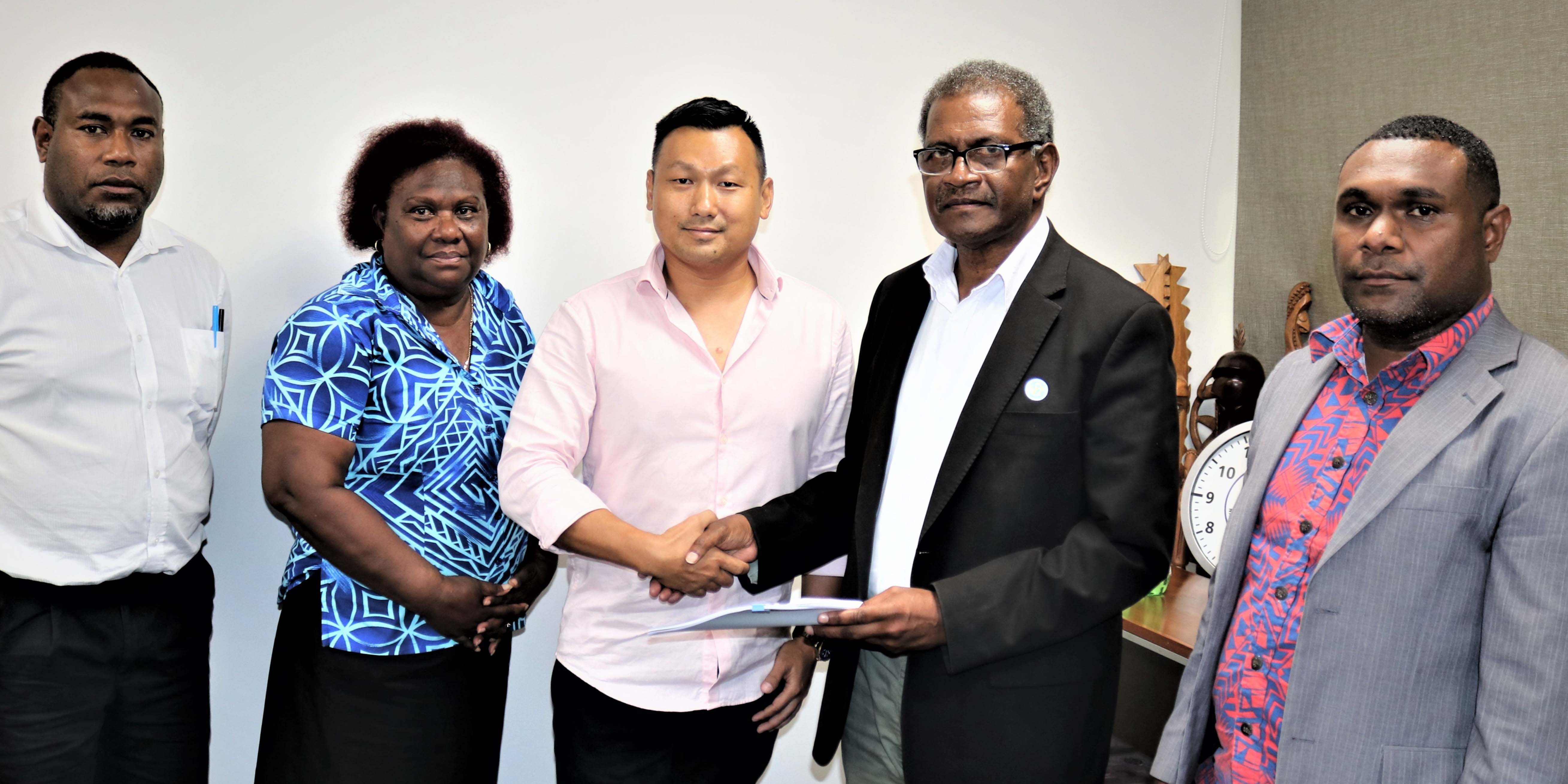 Managing Director and owner of Private Islands Investments Limited Mr David Leong shaking hands on the deal with the CEO/GM of SINPF Mr. Mike Wate. Looking on are senior officials of the Fund; Board Secretary Ms Ruth Alepio, Manager Legal Services Mr Stanley Hanu and PIIL Legal Counsel Mr. Donald Marahare